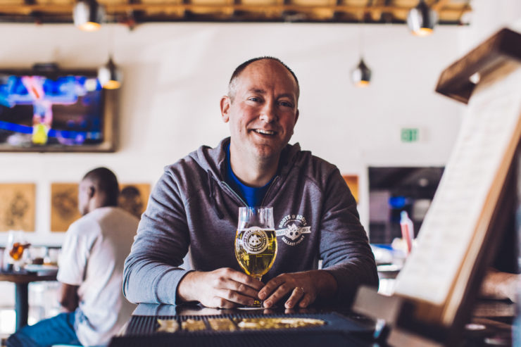 Ballast Point brewer Chris Hotz sits with a beer