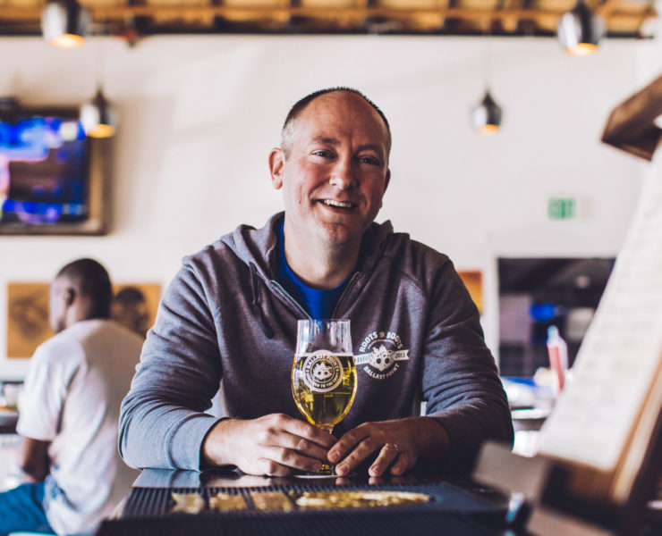Ballast Point brewer Chris Hotz sits with a beer